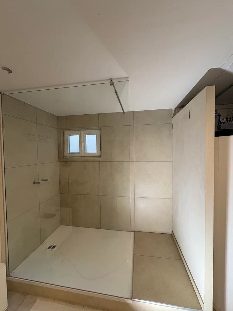 Douche à l'italienne avec paroi vitrée dans une salle de bain rénovée à Trélex