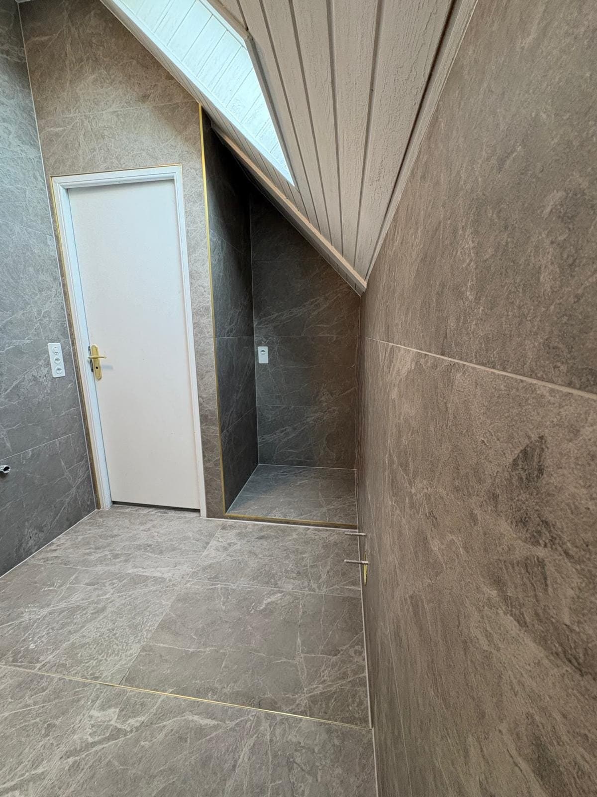 Niche sous pente carrelée dans une salle de bain à Crans