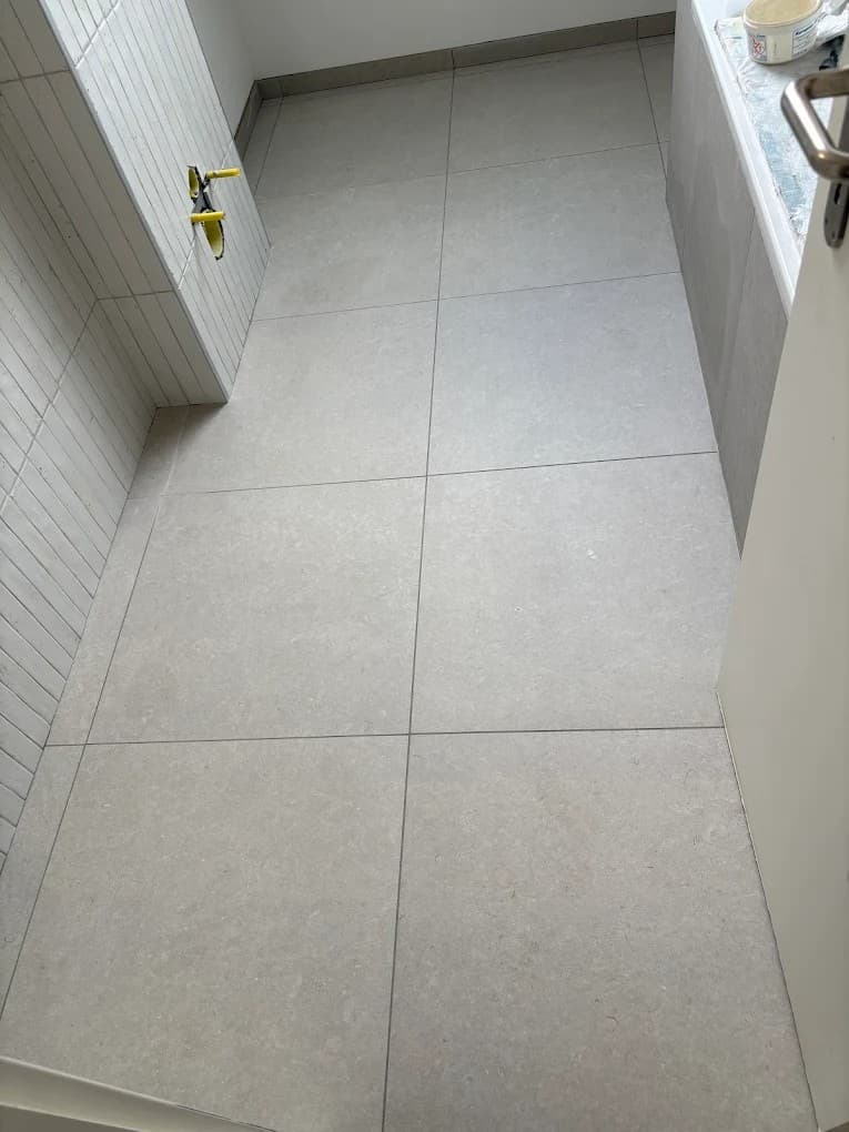 Carrelage de sol grand format posé dans une salle de bain à Trélex