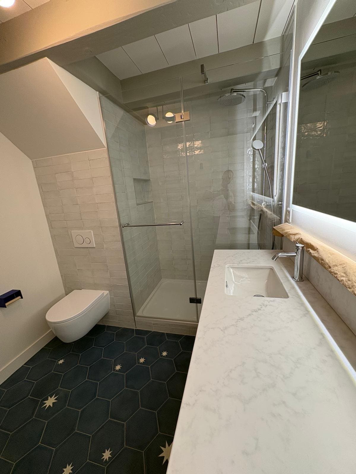 Douche vitrée et meuble vasque dans une salle de bain à Chéserex