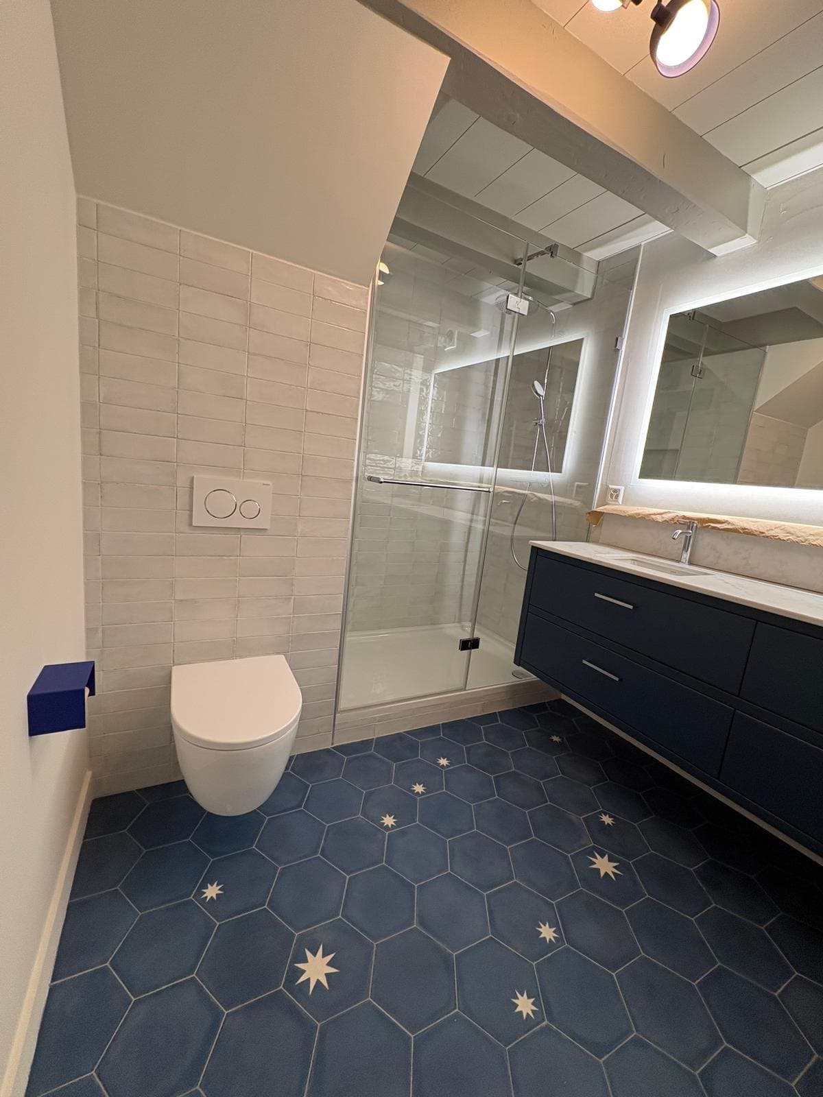 Douche fermée et WC suspendu dans une salle de bain à Chéserex